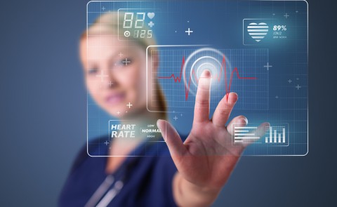 Young nurse standing and pressing modern medical type of buttons
